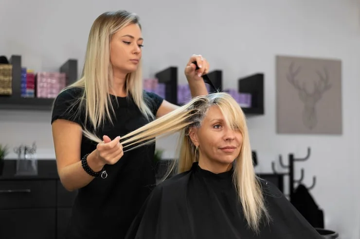 Kappers kleuren het haar van een klant in een professionele kapsalon