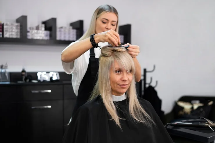 Kappers stylen het haar van een klant in een warme kapsalon