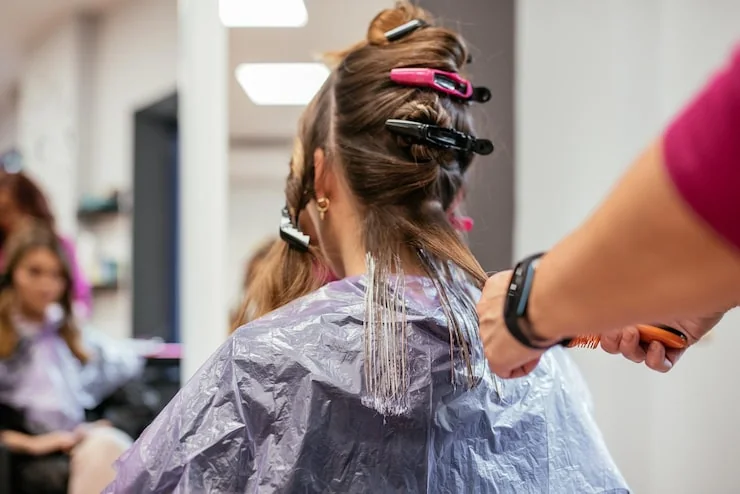 Kappers verven het haar van een klant zorgvuldig in de kapsalon